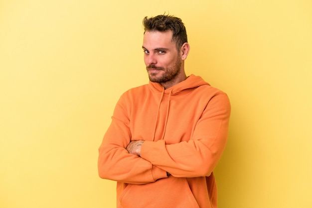 Young caucasian man isolated on yellow background unhappy looking in camera with sarcastic expression.