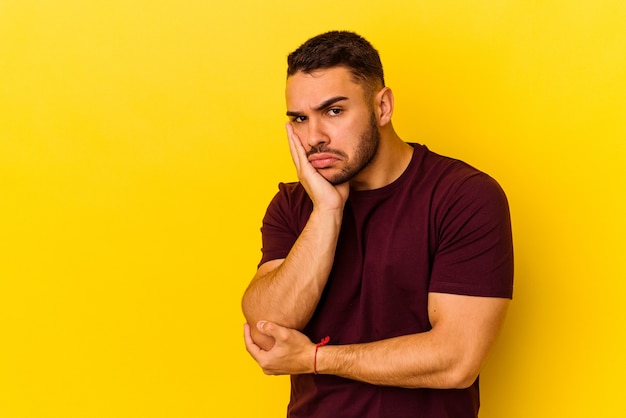 Young caucasian man isolated on yellow background who feels sad and pensive, looking at copy space.