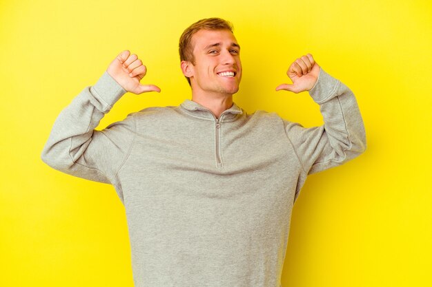 Young caucasian man isolated on yellow background