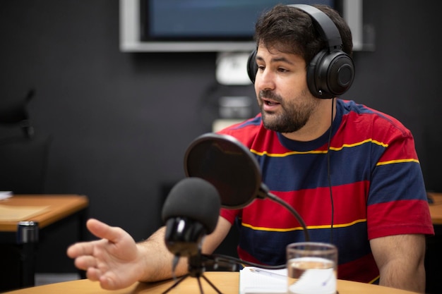 Young caucasian man during live broadcast of a radio programme