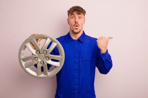 Young caucasian man looking astonished in disbelief car repairman concept