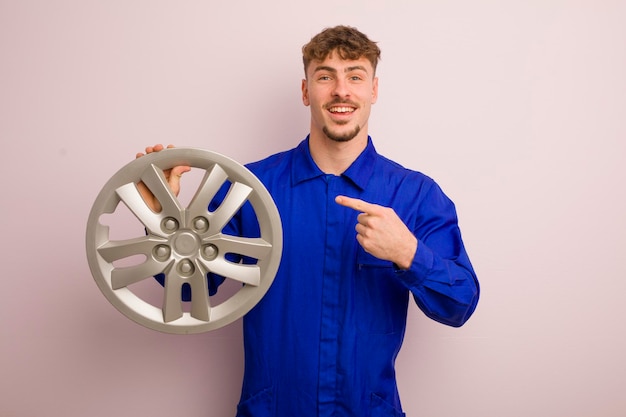 Young caucasian man looking excited and surprised pointing to the side car repairman concept