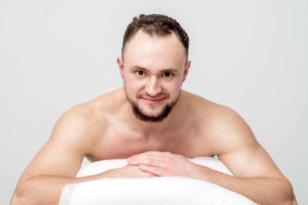 Young caucasian man lying on front on table spa, waiting for beauty treatment