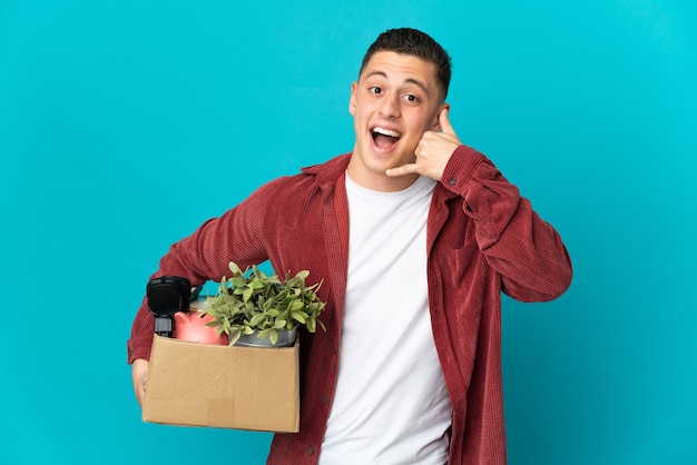 Young caucasian man making a move while picking up a box full of things isolated