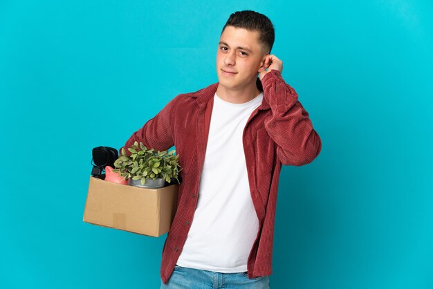Young caucasian man making a move while picking up a box