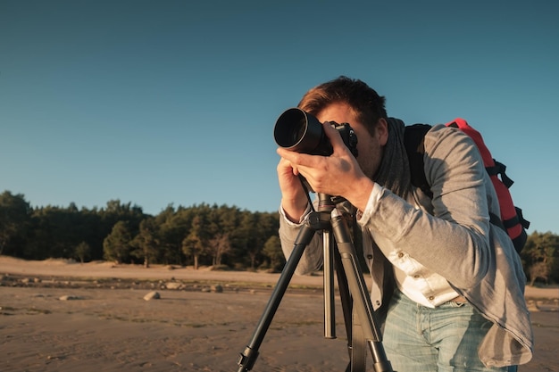 海辺の風景の写真を作る若い白人男性