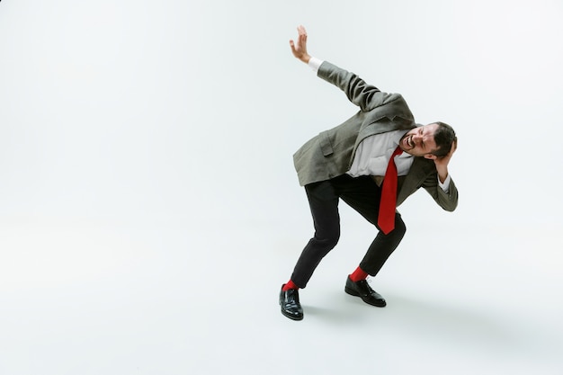 Photo young caucasian man moving flexible on white