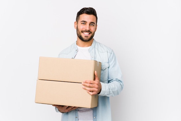 Young caucasian man moving to a new home isolated happy, smiling and cheerful.