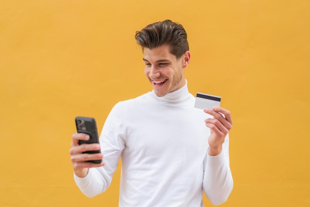 Young caucasian man at outdoors buying with the mobile with a credit card