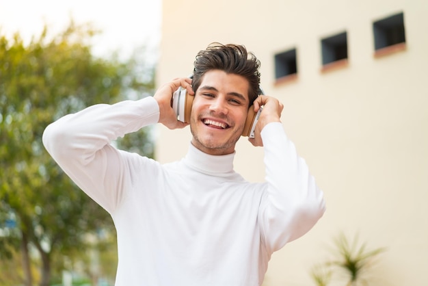 屋外で音楽を聴く若い白人男性