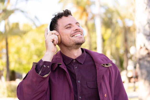 Young caucasian man at outdoors listening music