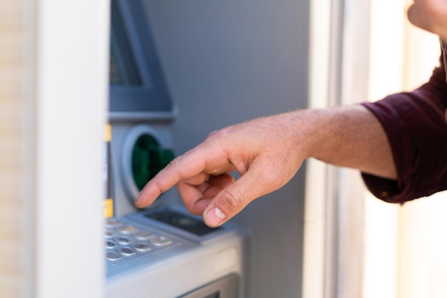 ATM을 사용하여 야외에서 젊은 백인 남자