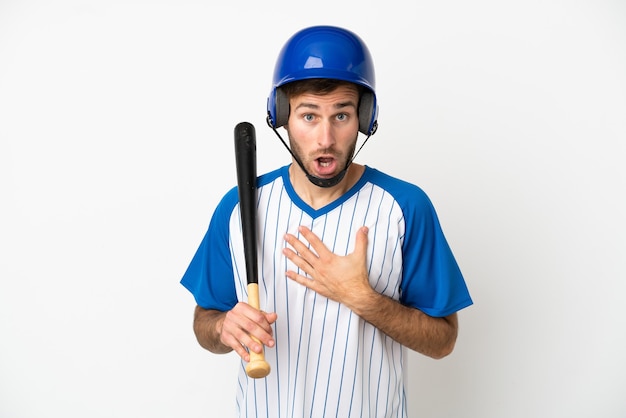 Young caucasian man playing baseball isolated on white background surprised and shocked while looking right