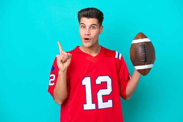 Young Caucasian man Playing rugby isolated on blue background intending to realizes the solution while lifting a finger up