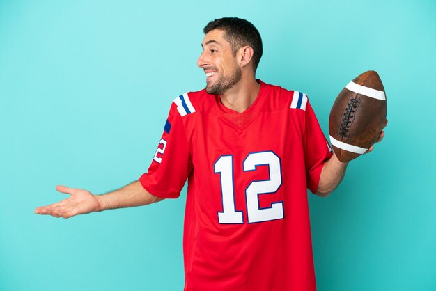 Young caucasian man playing rugby isolated on blue background with surprise expression while looking side