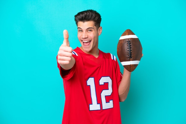 Young Caucasian man Playing rugby isolated on blue background with thumbs up because something good has happened