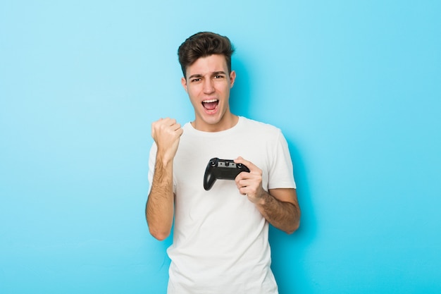 Young caucasian man playing videogames with game controller cheering carefree and excited.