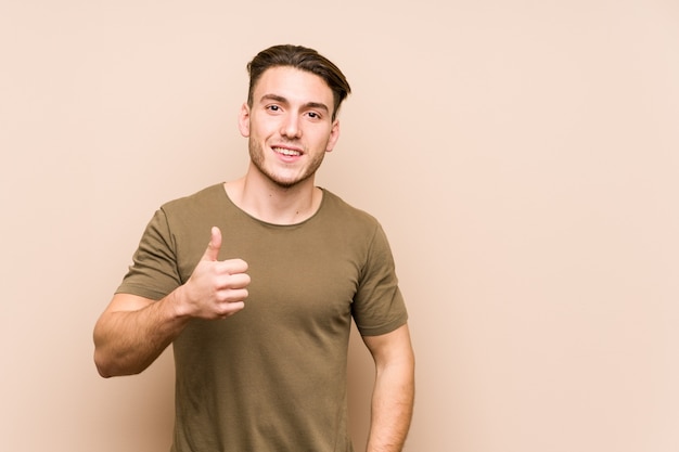 Young caucasian man posing isolated smiling and raising thumb up