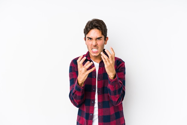 Young caucasian man posing in a pink isolated upset screaming with tense hands.