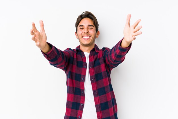 Young caucasian man posing in a pink wall isolated feels confident giving a hug to the camera.