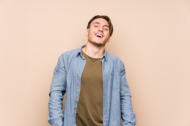 Young caucasian man posing relaxed and happy laughing