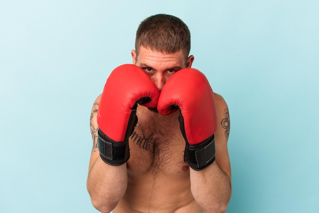 Young caucasian man practicing boxing isolated on blue background