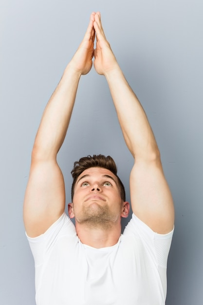 Young caucasian man practicing yoga indoor