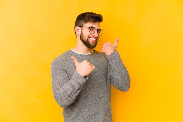 Young caucasian man raising both thumbs up, smiling and confident.