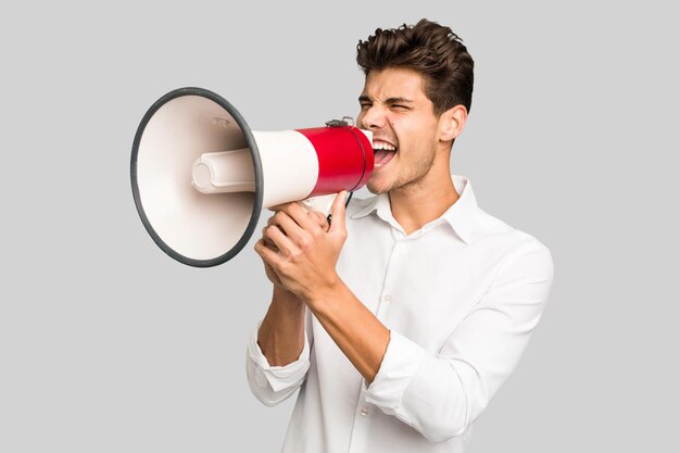 young caucasian man screaming with a megaphone isolated