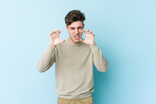 Young caucasian man showing claws imitating a cat, aggressive gesture.