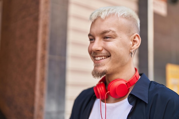 Young caucasian man smiling confident wearing headphones at street