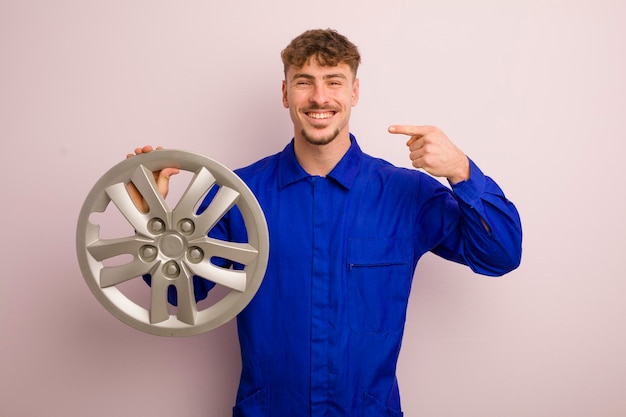 Young caucasian man smiling confidently pointing to own broad smile car repairman concept