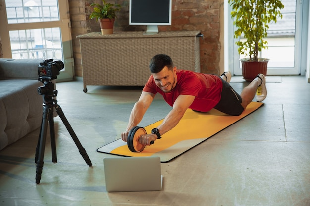 Young caucasian man training at home during quarantine