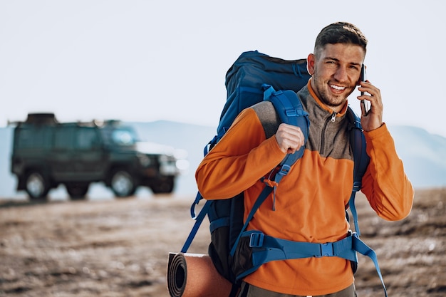 Viaggiatore di giovane uomo caucasico utilizzando il suo smartphone