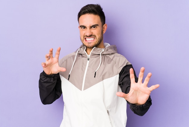 Young caucasian man upset screaming with tense hands.