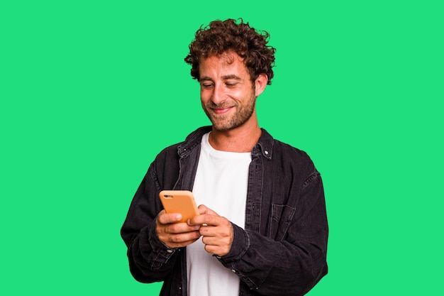 Young caucasian man using mobile phone isolated