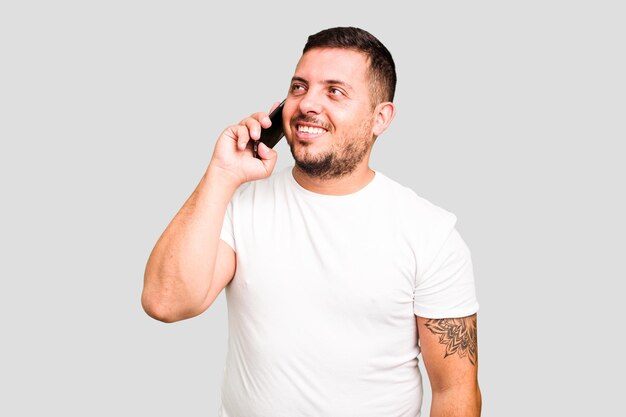 Young caucasian man using mobile phone isolated