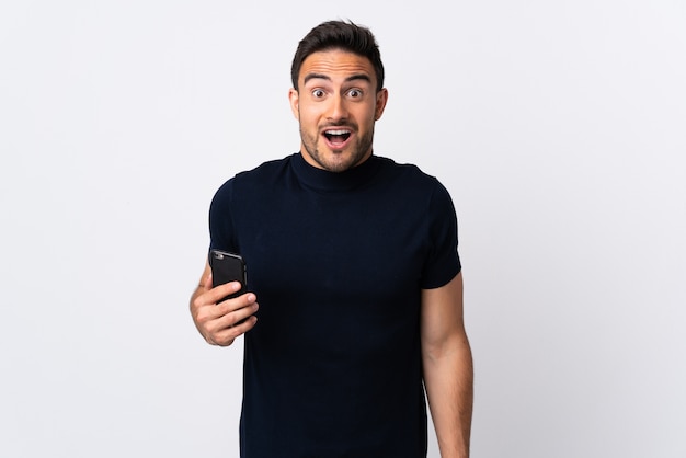 Young caucasian man using mobile phone isolated