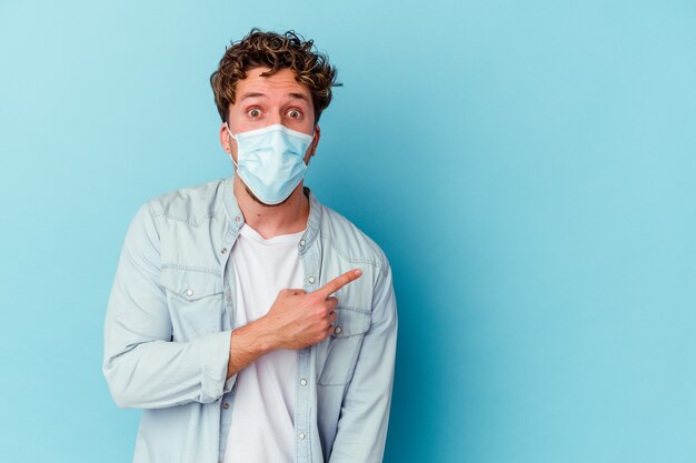 Young caucasian man wearing an antiviral mask isolated