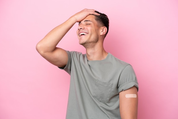 Young caucasian man wearing bandaids isolated on pink background has realized something and intending the solution