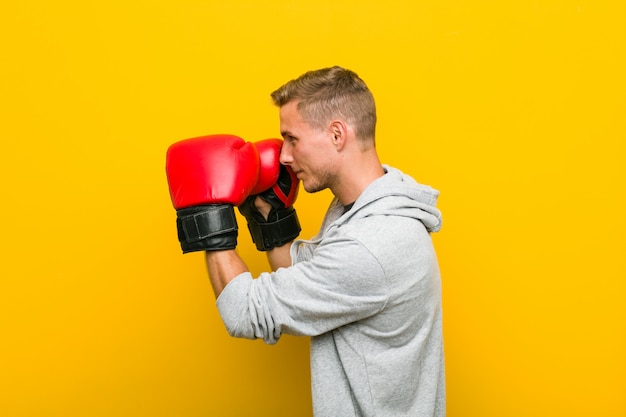 Young caucasian man wearing a boxing gloves