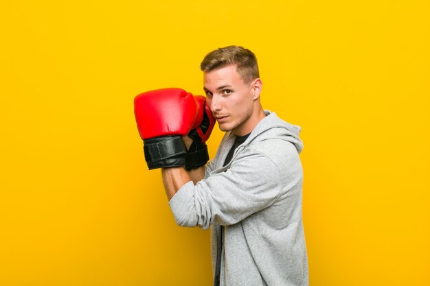 Young caucasian man wearing a boxing gloves