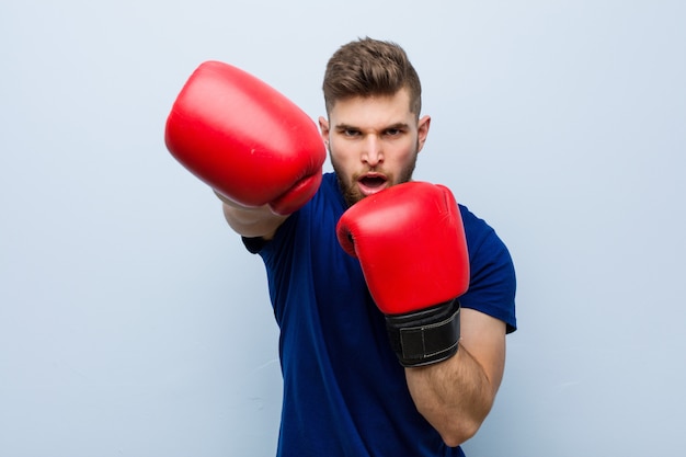 Young caucasian man wearing a boxing gloves