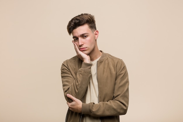 Young caucasian man wearing a brown jacket who is bored, fatigued and need a relax day.