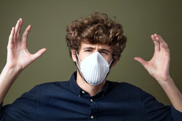 Young Caucasian man wearing a protective mask suffering from air pollution