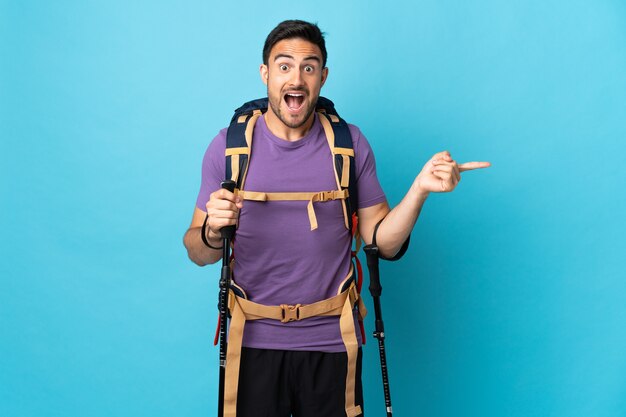 Young caucasian man with backpack and trekking poles