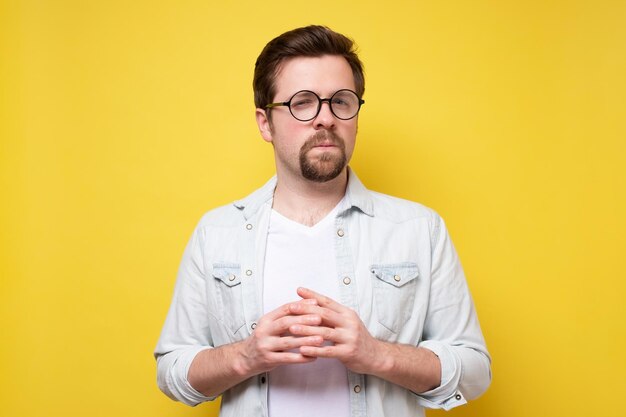 Young caucasian man with beard looking at camera without emotions