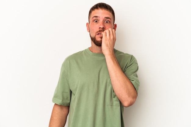 Young caucasian man with diastema isolated on white background biting fingernails, nervous and very anxious.
