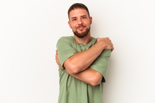 Young caucasian man with diastema isolated on white background hugs, smiling carefree and happy.