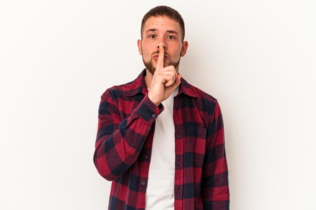 Young caucasian man with diastema isolated on white background keeping a secret or asking for silence.